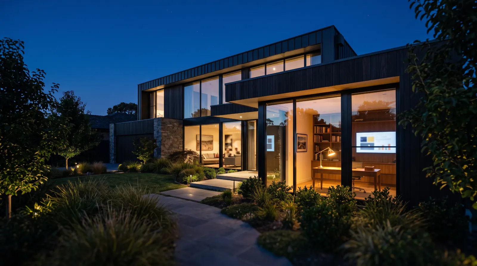 Modern house with large glowing windows at blue hour