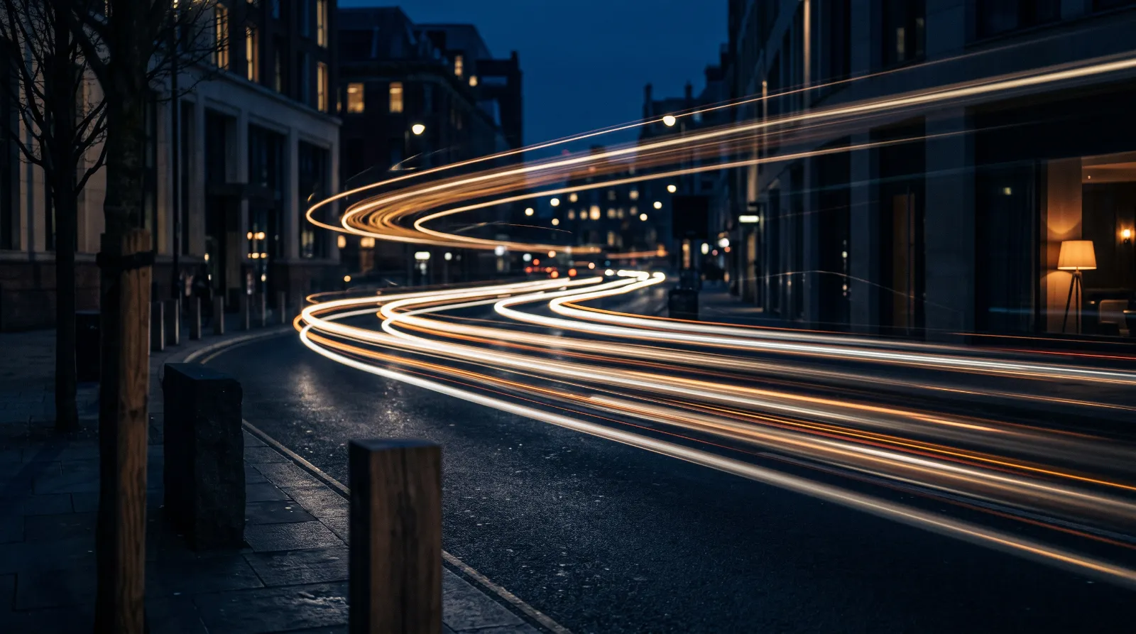 Long-exposure light trails streaking along a dark city road at night